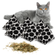Eine graue Katze mit orangefarbenen Augen sitzt neben fünf dreieckigen, gepunkteten Katzenminze-Spielzeugen und einem Haufen getrockneter Katzenminzblätter.
