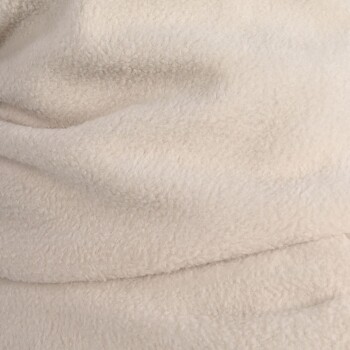 Eine Nahaufnahme einer weichen, beigen Haustierdecke mit plüschiger Textur, ideal um Haustiere warm und gemütlich zu halten.