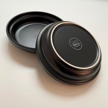 Schwarze Futterschüssel oder Wasserschüssel für Haustiere mit einem glatten, runden Design, vor einem weißen Hintergrund.