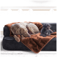 Ein grauer Weimaraner und ein kleiner schwarzer Pudel, die auf einer dunklen Couch ruhen, die mit einer weichen braunen Decke bedeckt ist.