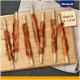 Vitakraft Haustierleckerlis auf einem Holzbrett, mit sieben stickförmigen Snacks, die in Fleisch eingewickelt sind, beschriftet mit "Länge ca. 12–13 cm."