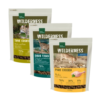 Drei Säcke Hundefutter mit der Aufschrift 'Wilderness', die Geschmäcker enthalten: True Country (Huhn mit Fisch), Dark Ford (Wildschwein & Geflügel) und Pure Chicken.