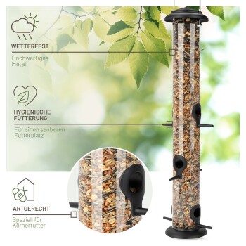 Ein hoher, klarer Vogelhäuschen mit schwarzen Öffnungen und einem stabilen Sockel, beschriftet mit "Wetterfest," "Hygienische Fütterung," und "Artgerecht."