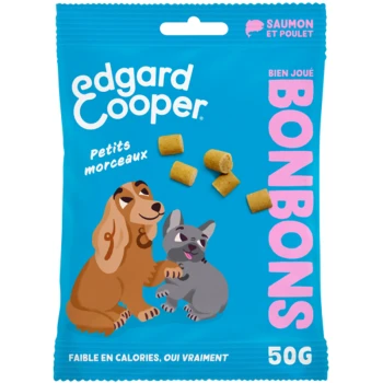Un sac bleu vif de friandises pour animaux Edgard Cooper avec des illustrations de dessins animés d'un chien et d'un chat, avec le texte "BONBONS" et "Saumon et Poulet."