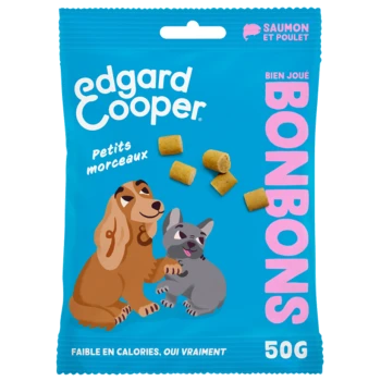 Un sac bleu vif de friandises pour animaux Edgard Cooper avec des illustrations de dessins animés d'un chien et d'un chat, avec le texte "BONBONS" et "Saumon et Poulet."