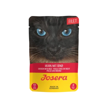 Nahaufnahme des Gesichts einer schwarzen Katze mit blauen Augen auf einem Katzenfutterbeutel mit der Aufschrift "Huhn mit Rind", "Josera", getreidefrei und hergestellt in Deutschland.