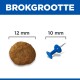 BROKGROOTTE met een hondenbrok van 12 mm naast een blauwe punaise van 10 mm voor groottevergelijking.