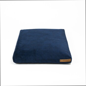 Marineblaues Haustierbett mit glatter Textur und einem kleinen braunen Etikett an der Seite, vor einem weißen Hintergrund.