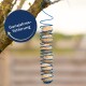 Ein blauer Spiral-Futterspender, der von einem Baumzweig hängt und mehrere Vogelfutterbälle hält, mit einem runden Etikett, das "Ganzjahresfütterung" liest.
