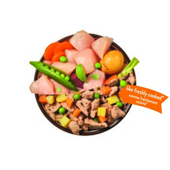 Schale mit Tierfutter mit rohem Huhn, gekochten Fleischstücken, Erbsen, Karotten und Kartoffel; orangefarbener Aufkleber „wie frisch gekocht*“