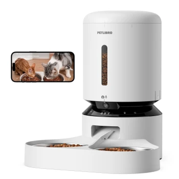 Automatischer Futterspender für Haustiere mit Kamera, der zwei Katzen zeigt, die aus Schalen fressen, und einem Smartphone, das die Futtereinrichtung anzeigt.