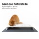 Eine flauschige orange Katze frisst von einer weißen erhöhten Futterstation mit drei Schalen auf einer grauen Matte. Text: "Saubere Futterstelle, BPA-frei."