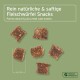 Rein natürliche & saftige Fleischwürfel-Snacks, etwa 1 cm groß, auf einem grünen Hintergrund verstreut.