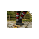Nahaufnahme der Beine einer Person, die schwarze wasserdichte Stiefel und bunte argyle-musterte Socken trägt, die auf einem Steinweg stehen, der mit Herbstblättern bedeckt ist.