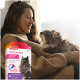 Une personne en pull confortable tient un chat près d'une fenêtre, avec une boîte de Beaphar CatComfort en spot-on apaisant au premier plan.