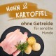 Huhn und Kartoffel ohne Getreide für sensible Hunde, mit einem ganzen Huhn, zwei Kartoffeln und frischem Rosmarin auf einem dunklen Hintergrund.