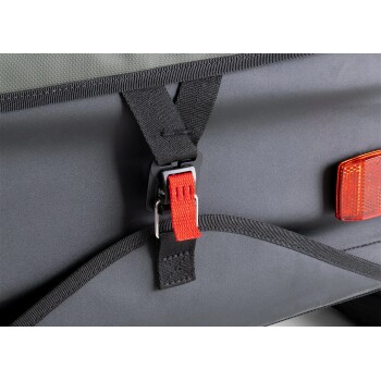 Nahaufnahme eines schwarzen Haustierträgers mit einem roten Schnallenriemen und reflektierenden Sicherheitsdetails, der strapazierfähige Materialien und eine sichere Befestigung zeigt.