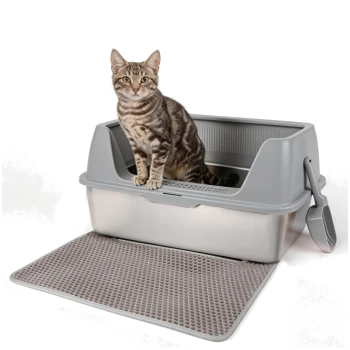 Getigerte Katze sitzt in einer grauen Katzentoilette mit hohem Rand, befestigter Schaufel und strukturierter grauer Streumatte und blickt in die Kamera
