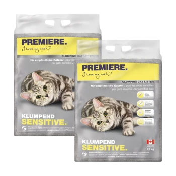 Twee zakken PREMIERE klonterende kattenbakvulling gelabeld "KLUMPEND SENSITIVE" met een speelse tabby kat op de voorkant, met meertalige tekst.
