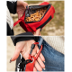 Eine Person, die eine rote Leckerlitasche für Haustiere hält, gefüllt mit braunen Leckerlis, mit einem Karabiner, der an ihrer Jeans befestigt ist.