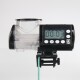 Digitaler Aquarienfütterer mit einem transparenten Behälter und einer Timeranzeige, die '00:03' zeigt, montiert auf einem Glastank.
