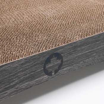 Nahaufnahme eines Kratzbretts für Katzen mit einer strukturierten Pappoberfläche und einer dunklen Holzunterlage mit einem eingravierten Blattlogo.