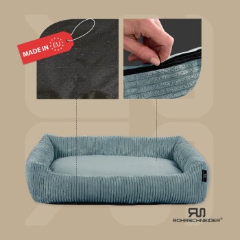 Ein plüschiges, hellblaues Haustierbett mit gerippter Textur, das eine Nahaufnahme des Reißverschlusses und einen schwarzen, rutschfesten Boden zeigt. Das Etikett lautet 'MADE IN EU.'