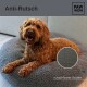 Ein glücklicher, flauschiger brauner Hund sitzt auf einem runden, grauen Haustierbett mit einem rutschfesten Boden. Der Text lautet "Anti-Rutsch" und "rutschfester Boden."