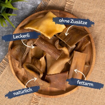 Ein Holzbrett gefüllt mit verschiedenen Hundeleckerlis, beschriftet mit den Texten: "Leckerli", "ohne Zusätze", "natürlich" und "fettarm."