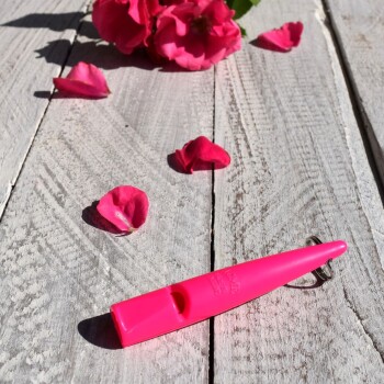 Hand hält eine rosa 80mm ACME Pfeife mit Schlüsselring, Metallclip und Bedienungsanleitung in Deutsch und Englisch.