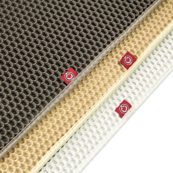 Drei strukturierte Haustiermatten in Dunkelgrau, Beige und Weiß, jede mit einem kleinen roten Logoetikett mit einem stilisierten Tier.