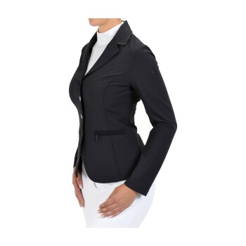 Eine Frau trägt eine taillierte schwarze Reitjacke mit Kragen und Knöpfen, kombiniert mit einem weißen Hemd und weißen Reithosen.