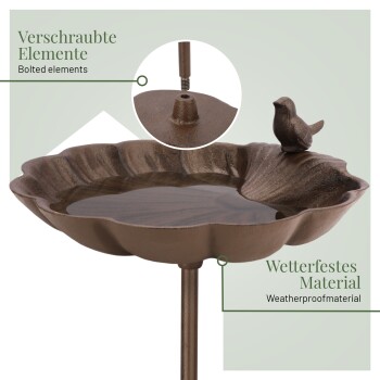 Ein blumenförmiger Vogelbad mit einer Vogelskulptur am Rand, beschriftet mit "Verschraubte Elemente" und "Wetterfestes Material."