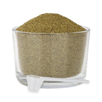 Ein Glasbehälter gefüllt mit einem feinen, grünlich-braunen Pulver, begleitet von einem kleinen weißen Messlöffel.