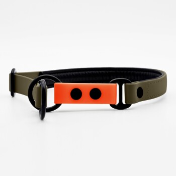 Ein stilvolles Hundehalsband mit einem olivgrünen Riemen, einem gepolsterten schwarzen Innenraum und einer leuchtend orangefarbenen Schnalle mit zwei schwarzen Punkten.