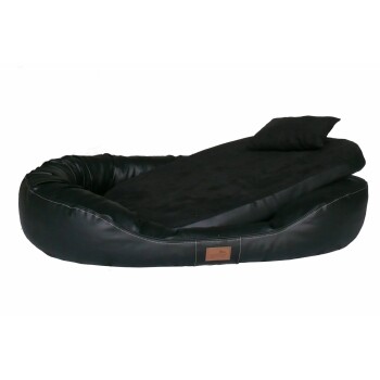 Schwarzes Haustierbett mit einem plüschigen Schlafbereich und einem abnehmbaren Kissen, mit einem kleinen braunen Etikett mit einem Logo.