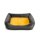 Graues Haustierbett mit einem weichen gelben Kissen, mit erhöhten Seiten für Komfort und einem kleinen Lederetikett an der Seite.