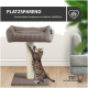 Eine getigerte Katze kratzt an einem beigen Katzenbaum mit einem gemütlichen, gerippten Bett oben, das mit "PLATZSPAREND" beschriftet ist, in einem modernen Wohnzimmer.
