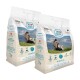 Zwei Säcke Swiss Natural Senior Mini Hundefutter, jeweils 1 kg, mit einer malerischen Kulisse mit einer Person und einem Hund.