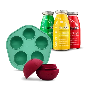 Drei SmoothieDog Snackflaschen mit den Aufschriften Lamm, Huhn, Rind, mit einer grünen Silikonform und einem roten Leckerball mit Snack innen.