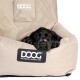 Schwarzer Welpe ruht in einem beigen DOOG-Hundebett mit dem Text „DOG OWNERS OUTDOOR GEAR“ auf dem vorderen Etikett.