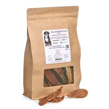 Eine braune Papiertüte mit Hundeleckerlis, beschriftet mit "Kyllingebrydstfilet", die getrocknete Hähnchenbrustfilets enthält, mit einem Fenster, das die Leckerlis im Inneren zeigt.