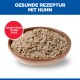 Gamelle de nourriture humide pour animaux avec gros morceaux au poulet ; titre bleu 'GESUNDE REZEPTUR MIT HUHN' ; badge rouge 'NASSFUTTER IN DER DOSE'.
