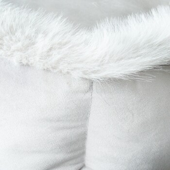 Nahaufnahme eines weichen, plüschigen Haustierbettes mit einem flauschigen weißen Fellrand, das seine gemütliche Textur und hellgraue Farbe zeigt.