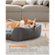 Ein entspannter Corgi schläft in einem gemütlichen grauen Haustierbett mit erhöhten Rändern, die Nackenstütze und ein Gefühl von Sicherheit bieten.
