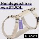 Beige Hundegeschirr von STUCH mit einem 'Vegan Approved'-Schild, das verstellbare Riemen und ein robustes Design hat.