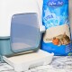 Eine Katzentoilette mit einer transparenten Tür steht neben einem Sack Lyra Pet Power Ultra Katzenstreu, mit einem schlafenden Kätzchen und einem Basketball-Graphic.