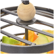 Eine Nahaufnahme eines metallenen Obsthalters mit einer Holzperle oben, gefüllt mit bunten Obstscheiben, darunter Orange und grüner Apfel.