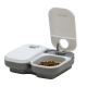 Automatischer Futterspender für Haustiere mit zwei Fächern, eines gefüllt mit Trockenfutter, mit einem Timer-Drehknopf auf dem Deckel für geplantes Füttern.
