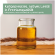 Glasgefäß mit Leinöl auf Holztisch; Text: 'Kaltgepresstes, natives Leinöl' und 'Cold-pressed, natural linseed oil'.